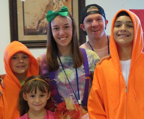 A family photo of a family at Family Retreat smiling at the camera.