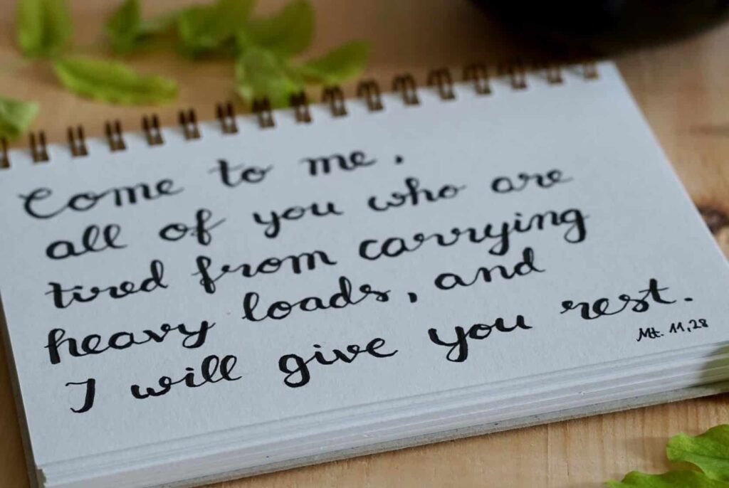 Close up of the verse Matthew 11:28 that reads, "Come to me, all of you who are tired from carrying heavy loads, and I will give you rest."