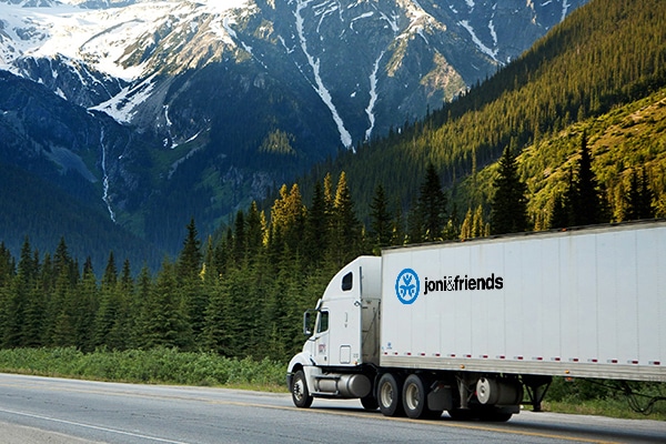 A truck with the Joni and Friends logo transports wheelchairs