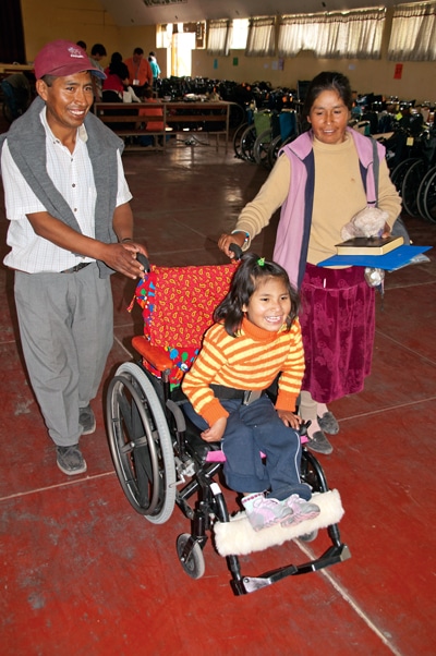 maria in her new wheelchair with her parents