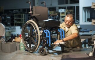 An inmate works on a wheelchair