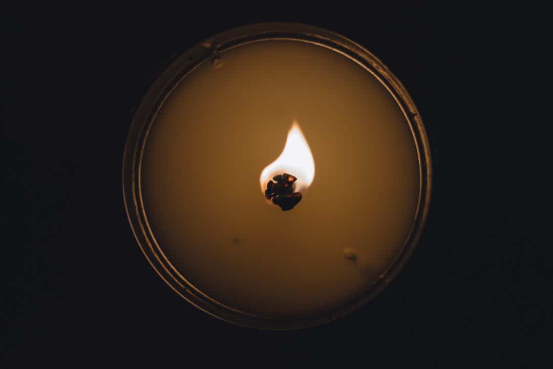 Close up of a candle wick burning.