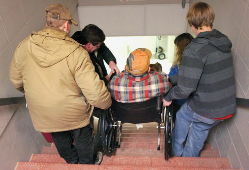 Carrying a man in a wheelchair Carrying a man in a wheelchair