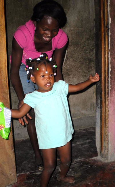 little girl walking into her classroom with the help of a therapist
