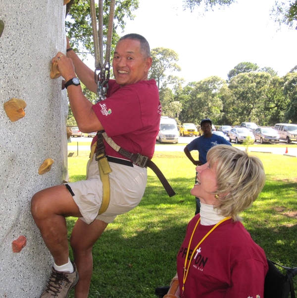 Press On into Fun and Fellowship Ken climbing the rock wall as Joni watches