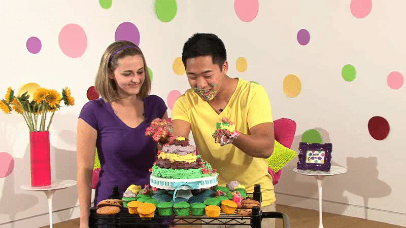 naomi and bobo in front of a big colorful cake