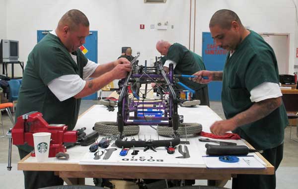 Inmates restoring wheelchairs for Wheels for the World Inmates restoring wheelchairs for Wheels for the World
