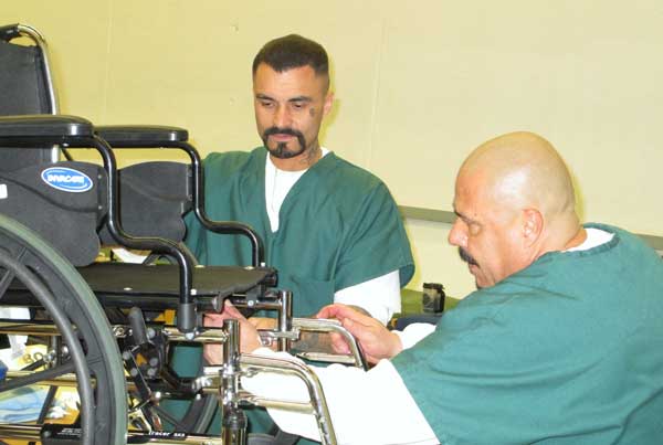 Inmates restoring wheelchairs for Wheels for the World Inmates restoring wheelchairs for Wheels for the World