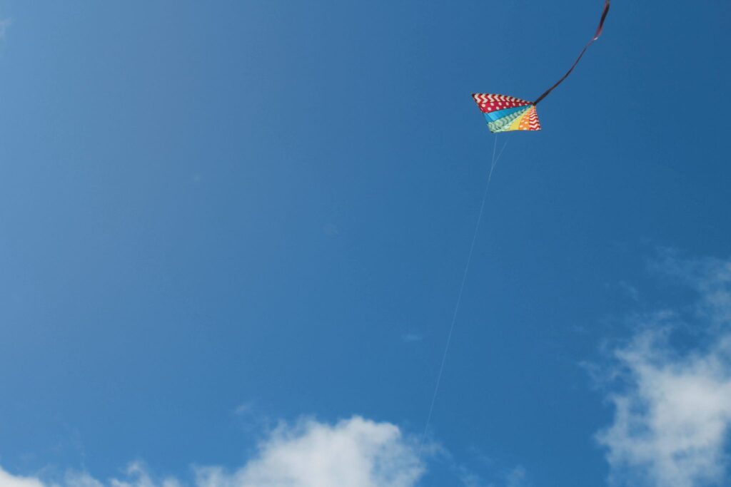 A kite flying in a bright blue sky.