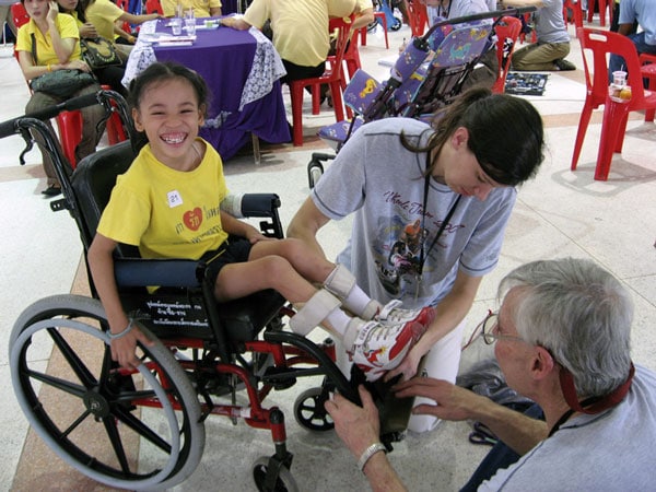 Wheels for the World A happy girl receives her first wheelchair from Wheels for the World