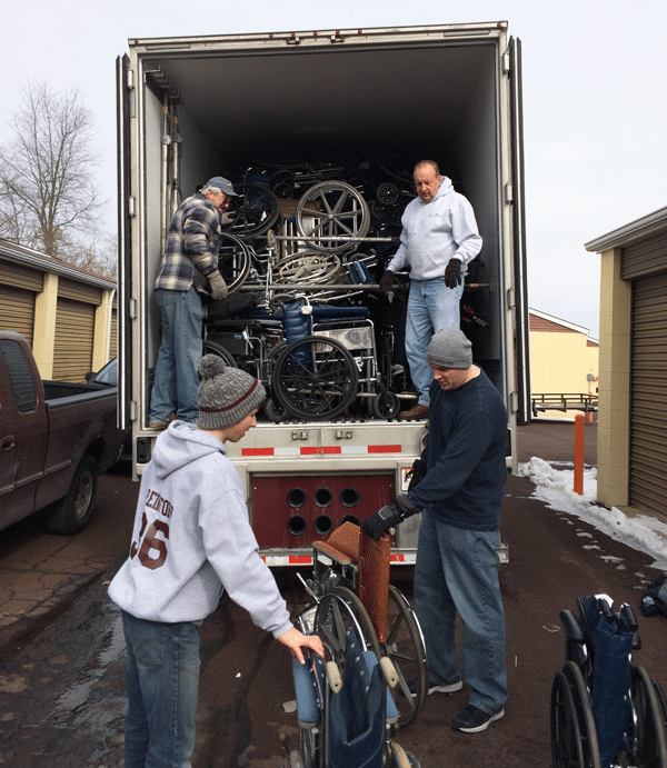Volunteers loading a truck with wheelchairs