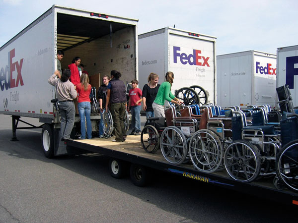 FedEx trucks with wheelchairs being loaded into them