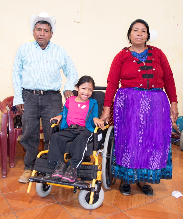 8-year-old Andrea in her new pediatric wheelchiar, with her parents 8-year-old Andrea in her new pediatric wheelchiar, with her parents