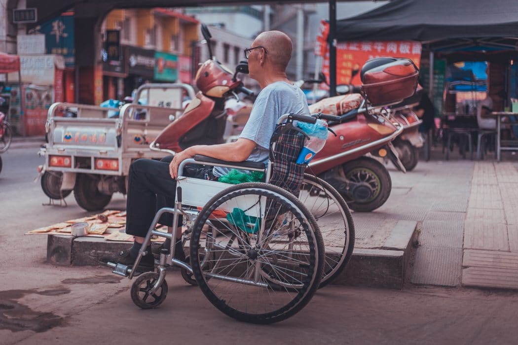 A man using a wheelchair on a city street.