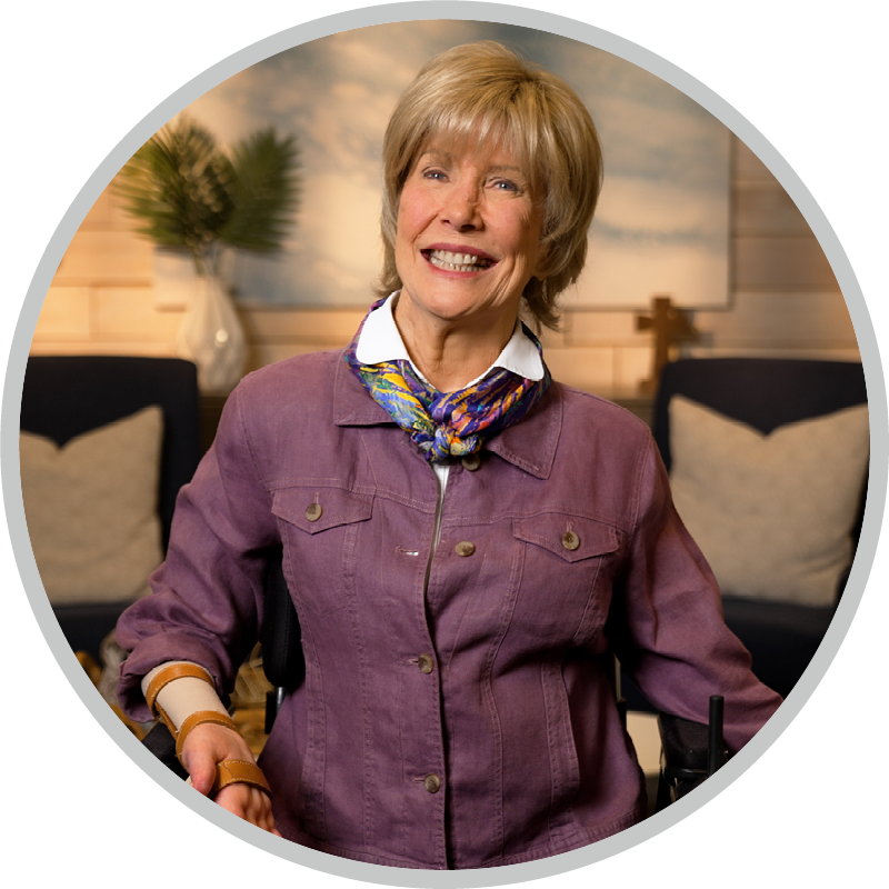 Joni Eareckson Tada smiles and poses for the camera in a cozy living room setting.