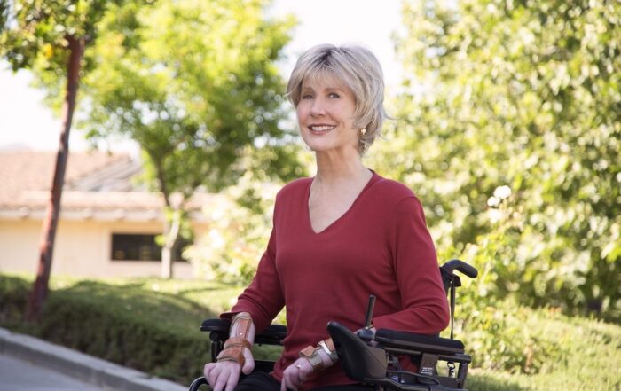 Joni in her wheelchair smiling for the camera.