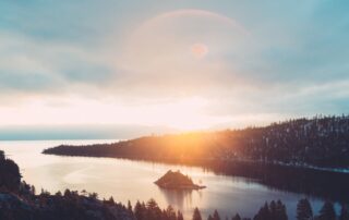 A beautiful view of the sun rising over a snowy, forested landscape.