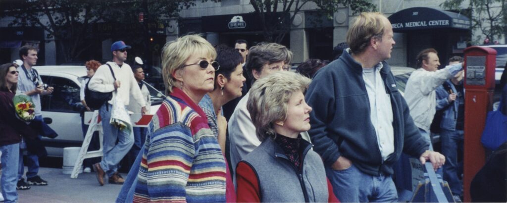 A picture of Joni wit a group of people looking out at the wreckage after the 9/11 attacks.