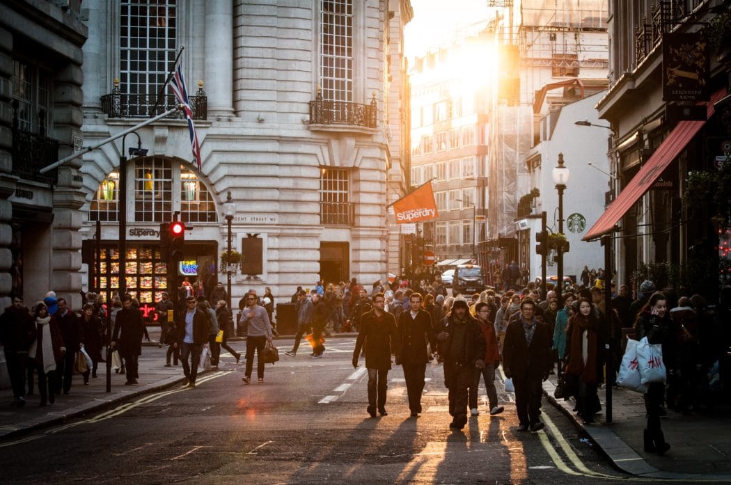 A scene overlooking a crowd of people walking the streets of a city.