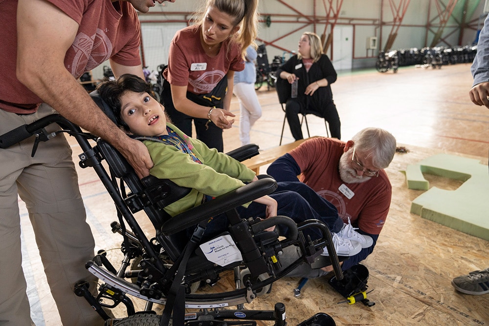 Volunteer fit a child to their new wheelchair