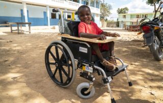 A child poses for a photo in his new wheelchair