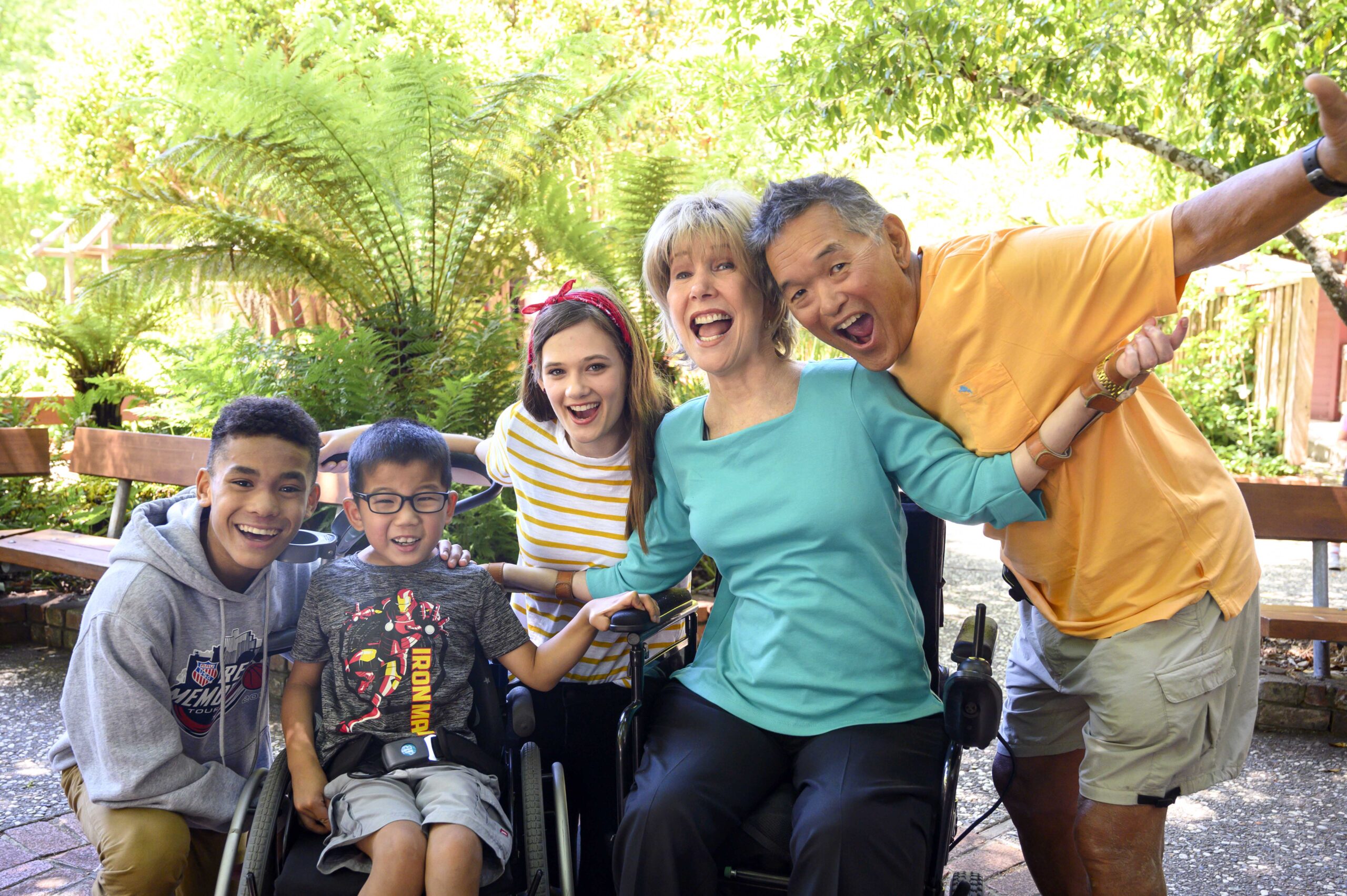A group photo of Joni, Ken and three children, on who is seated in a wheelchair, the other two on either side of him.