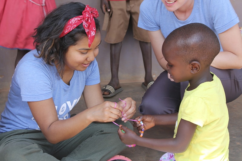 An intern give a child a Gospel Bracelet