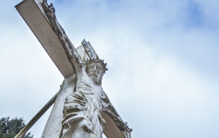 A view from below a statue of Jesus on the cross.