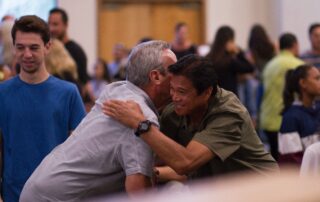 Two men hugging at a church service.