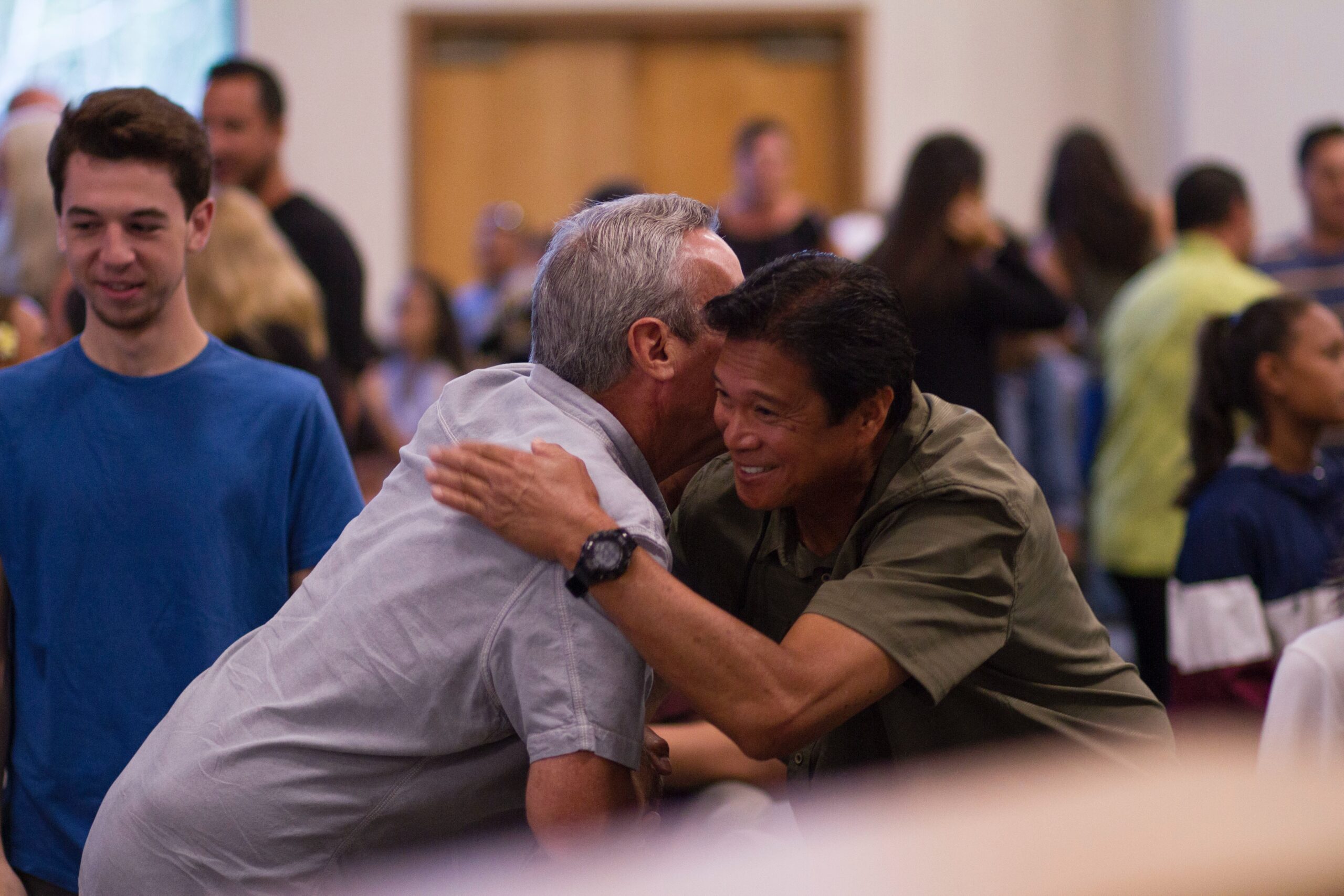 Two men hugging at a church service.