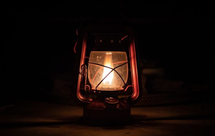 A picture of a lantern in the dark with a flame.