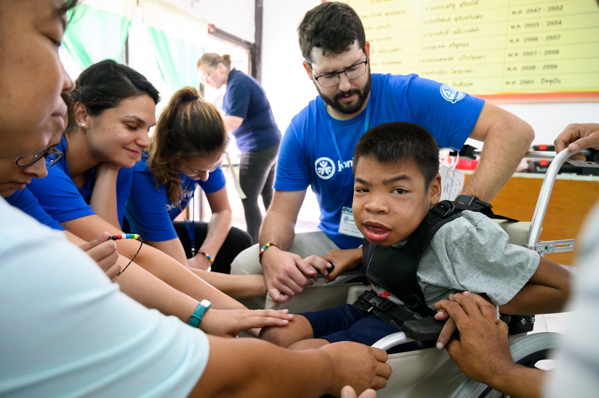 Volunteers adjusting a child's wheelchair