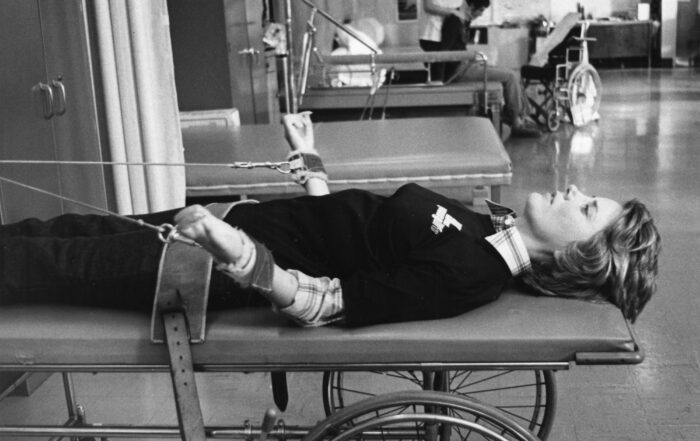 Joni laying on an exercise machine she used during her initial physical therapy after her accident.