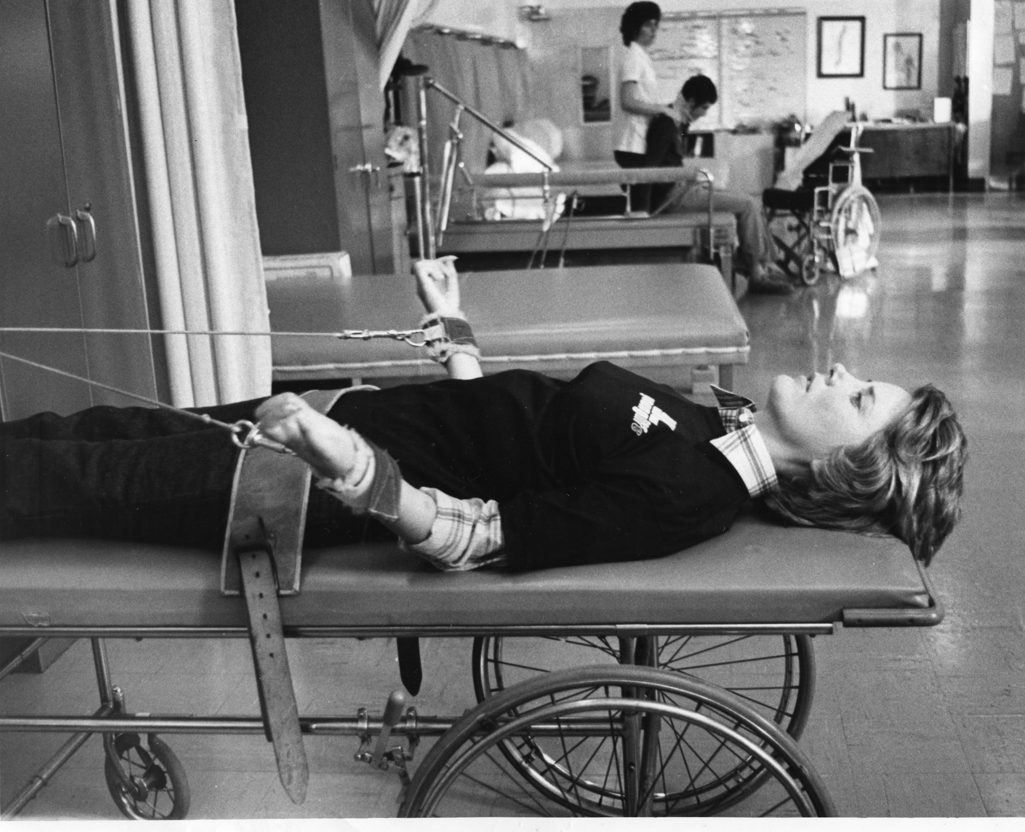 Joni laying on an exercise machine she used during her initial physical therapy after her accident.