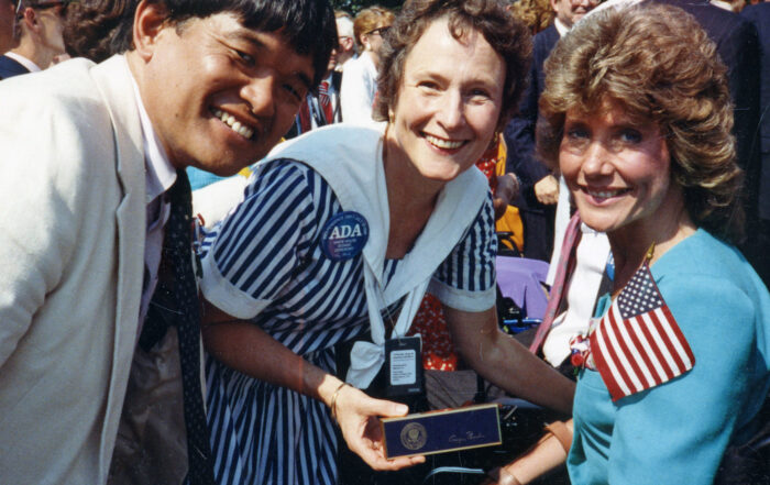 Ken Tada on the left, a woman in the middle, and Joni Eareckson Tada on the right, at the signing of ADA.
