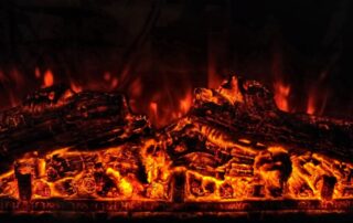 Close up of flaming logs in a fire pit.