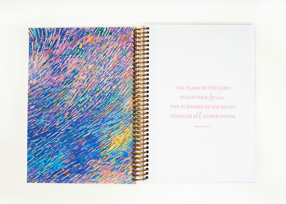 A close up picture of the 2021 Joni Planner with a multicolored design on the back and the verse "The plans of the Lord stand firm forever, the purposes of his heart through all generations," (Psalm 33:11).