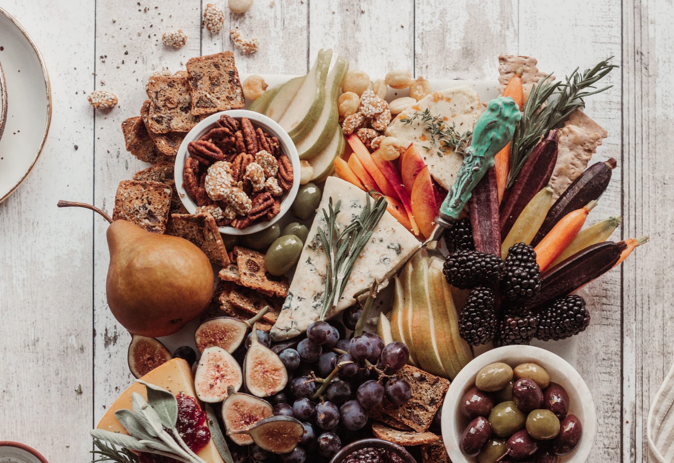 A view from above a charcuterie board with all kinds of fruits, crackers, and cheeses.