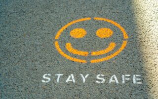 A picture of a spray-painted smiley face with the words "Stay Safe" spray painted below it.
