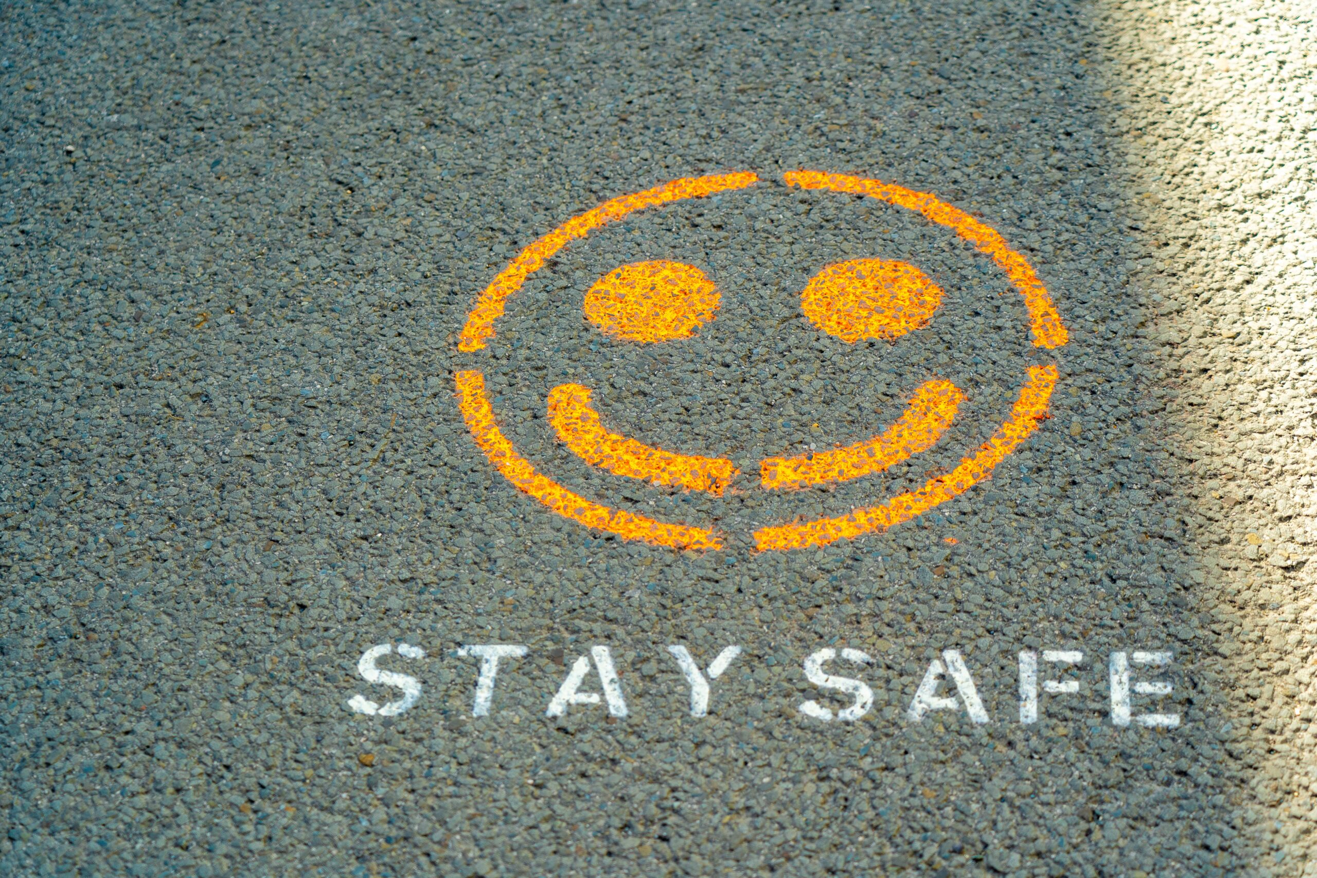 A picture of a spray-painted smiley face with the words "Stay Safe" spray painted below it.