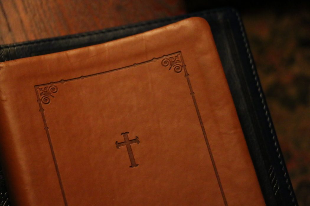 Close up of a leather bible with a small cross engraved in the center.