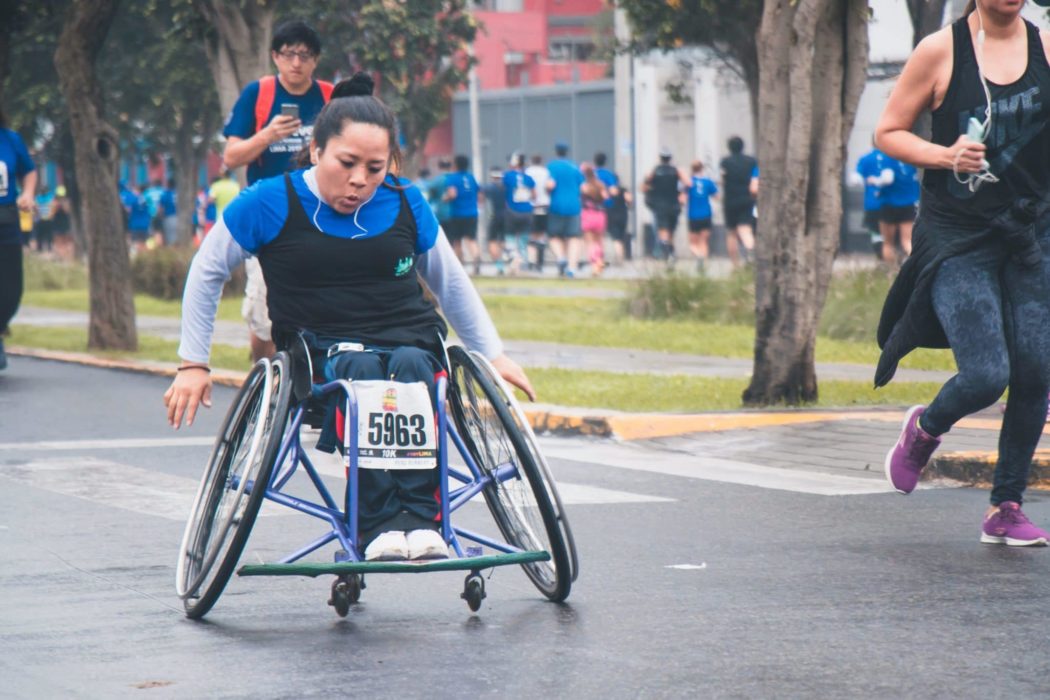 A woman in a wheelchair competing in a marathon.