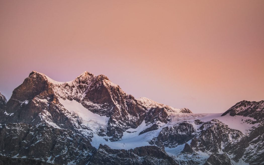 Snowy mountain range against a sunset sky.