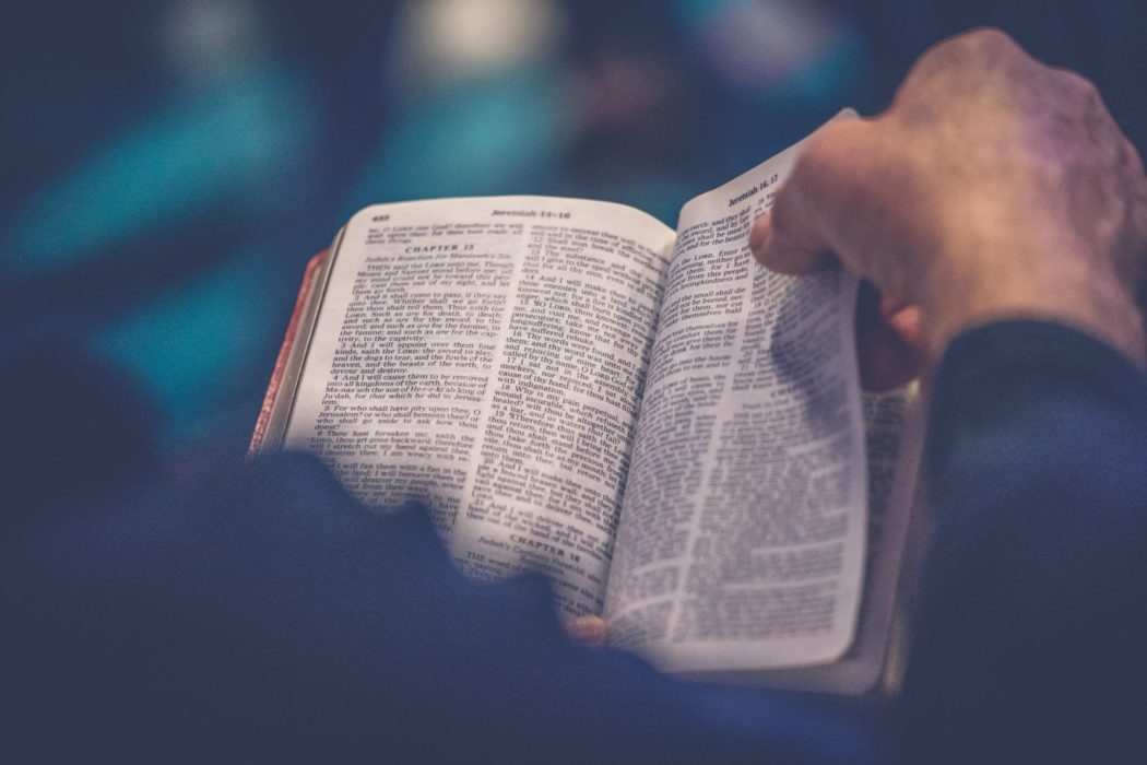 Close up of a bible as a man's hand flips the pages.