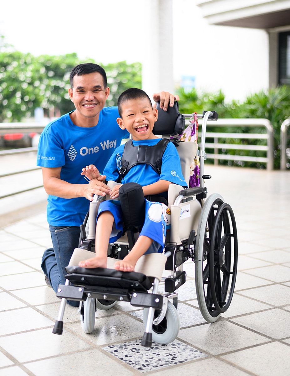 A volunteer and child in his new wheelchair