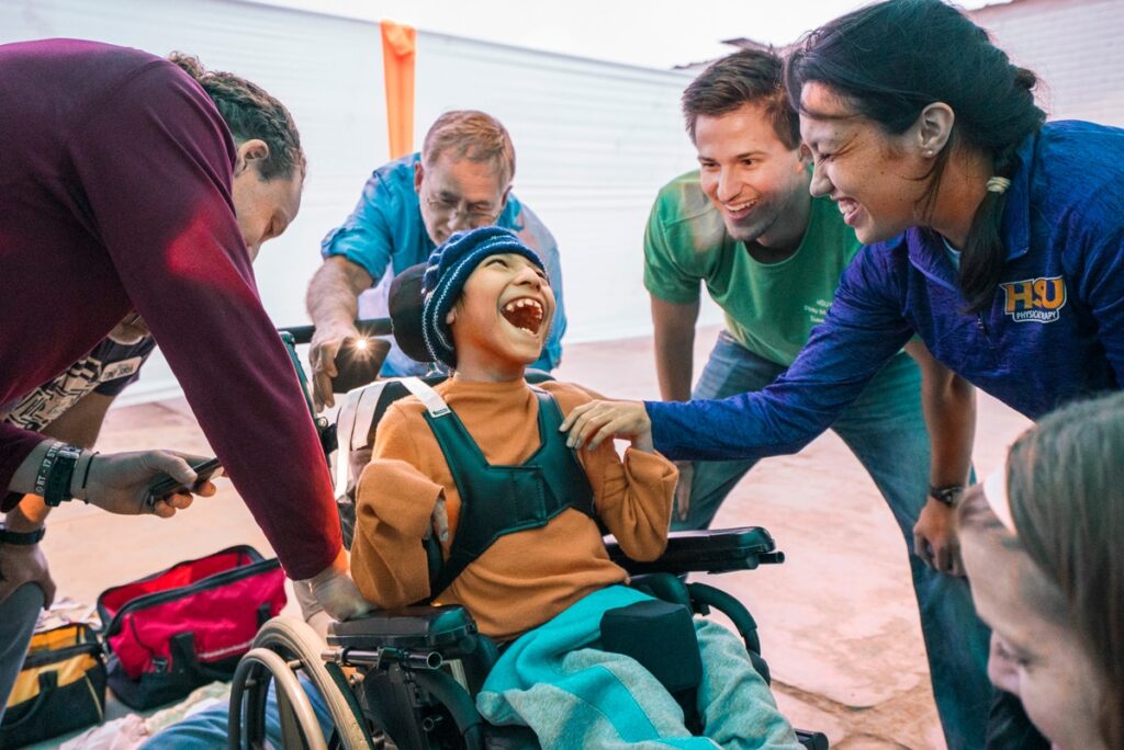 A child smiling in their new wheelchair