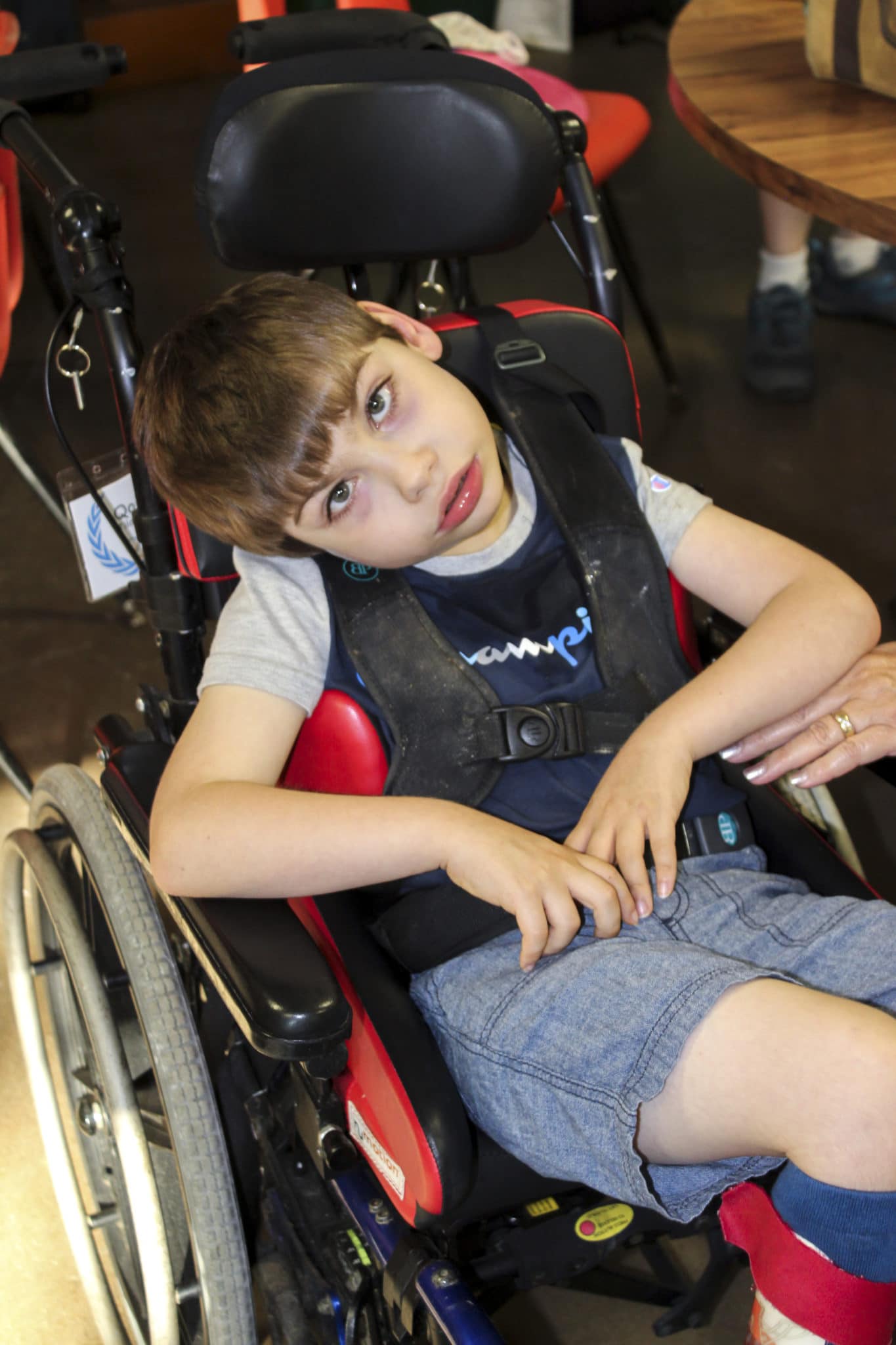 Qorban sits in his wheelchair looking up at the camera.