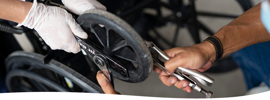 A wheelchair mechanic fixing a wheelchair