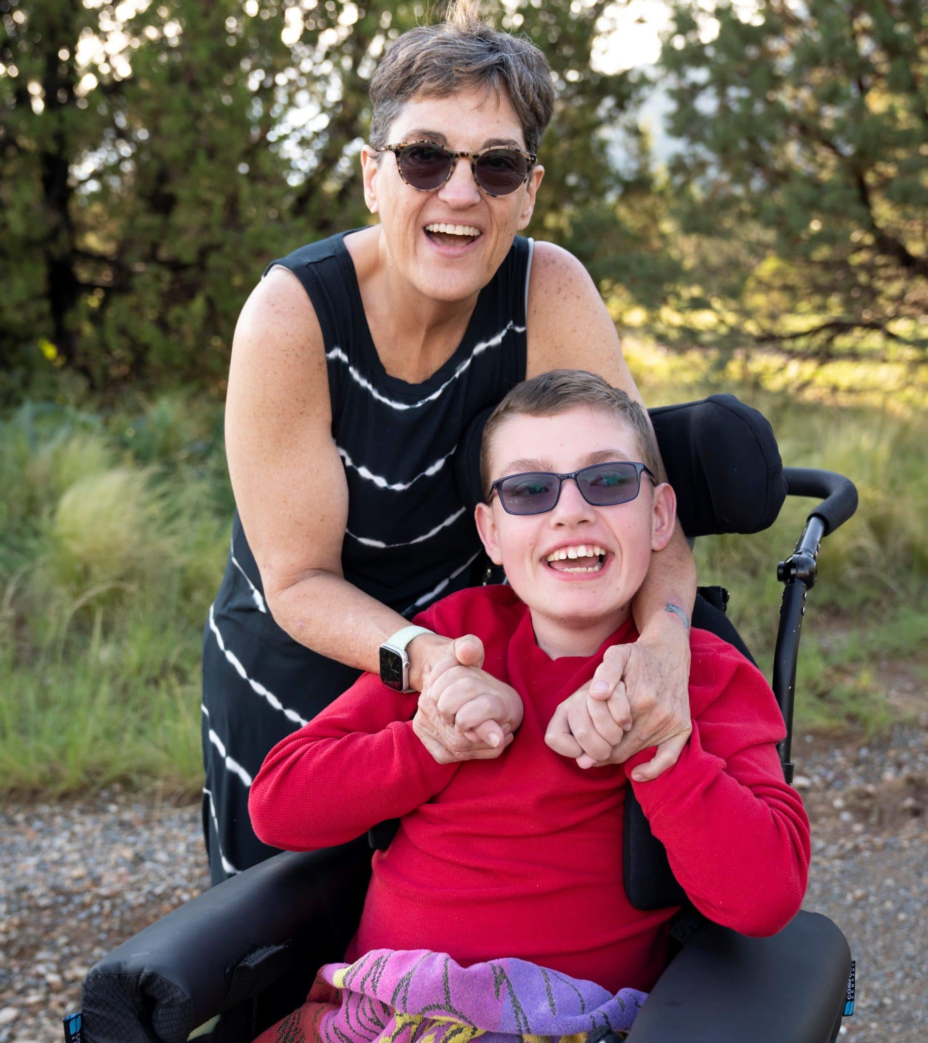 Julie stands next to Tyler, holding his hands. Both of them are smiling.