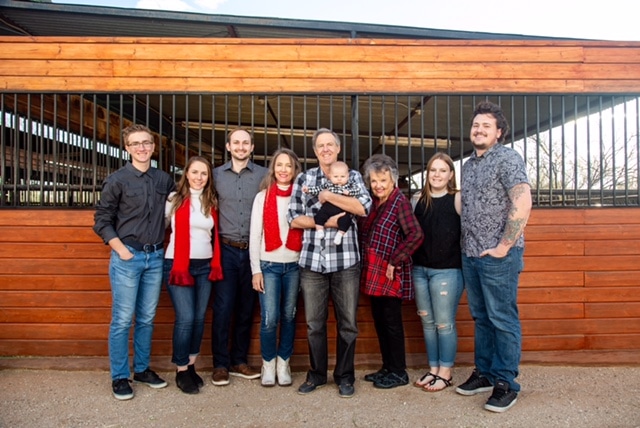 Dr. Laurie and his family, nine total people are in the photo spanning from a little baby to someone who looks like they could be the grandma.